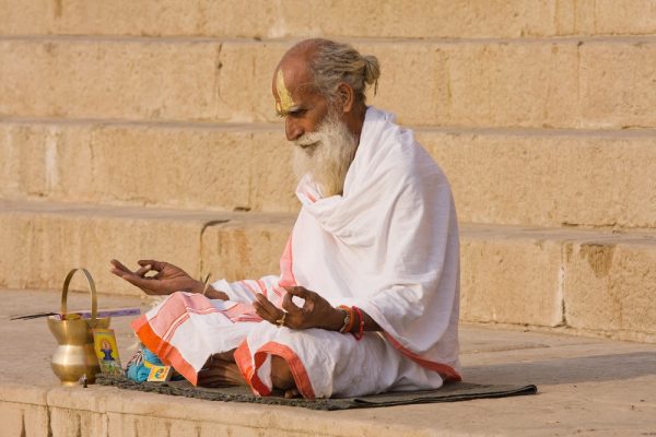 Indian old man doing yoga meditation
