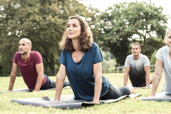 Group yoga class taking place in a local park
