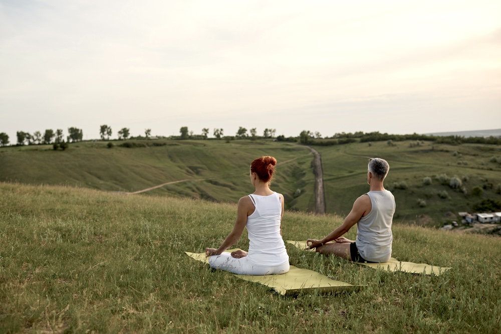 Couple meditating in an open space