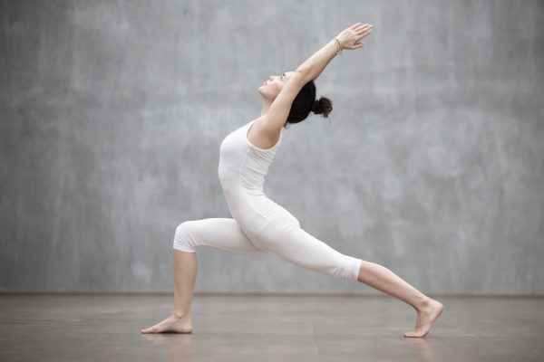 Female yogi in white doing a yoga pose