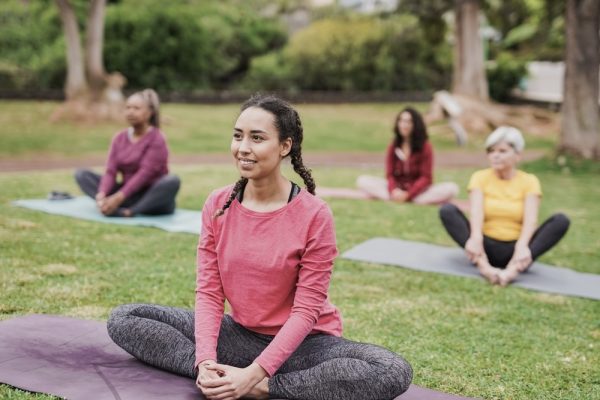 Women sitting cross-legged at an outdoor yoga class