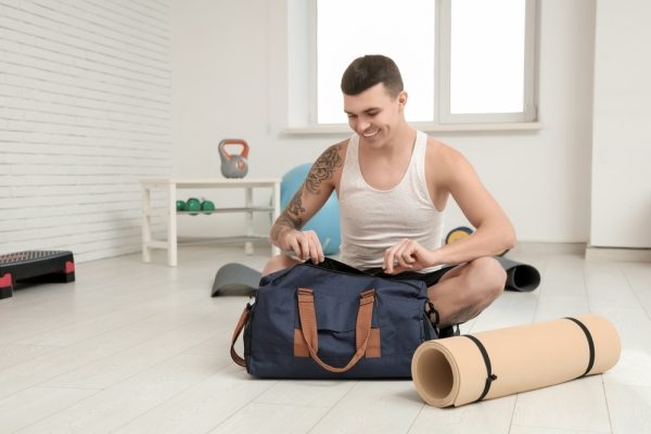 Man preparing his gym bag to go to yoga class