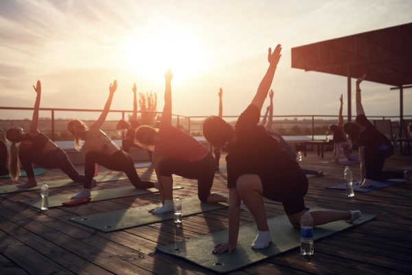 Group outdoor yoga class during sunset