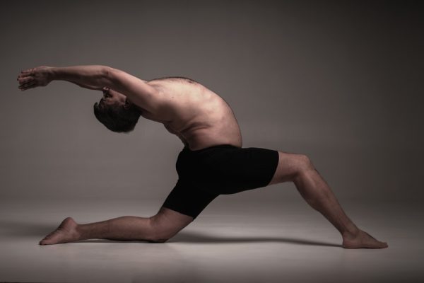 Man doing a difficult pose in an Ashtanga yoga class