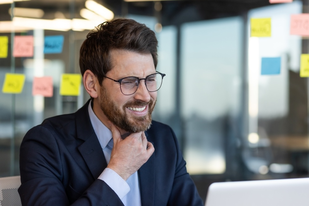 Man in the office having problem communicating due to blocked throat chakra