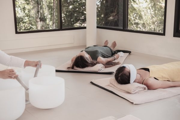 Two women attend a sound healing class wearing comfortable clothing